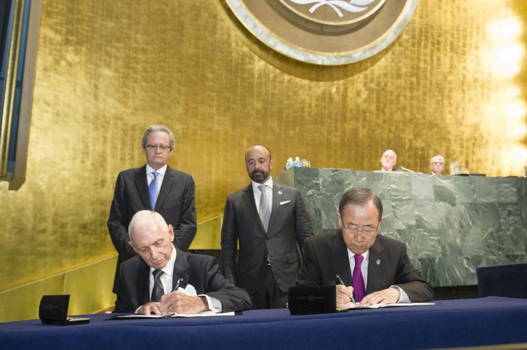 Bij de start van de VN-top voor Vluchtelingen en Migranten ondertekenen IOM Directeur-generaal William Lacy en VN Secretaris-generaal Ban Ki-moon de overeenkomst die van IOM een VN-gerelateerde organisatie maakt - © UN Photo/Rick Bajornas